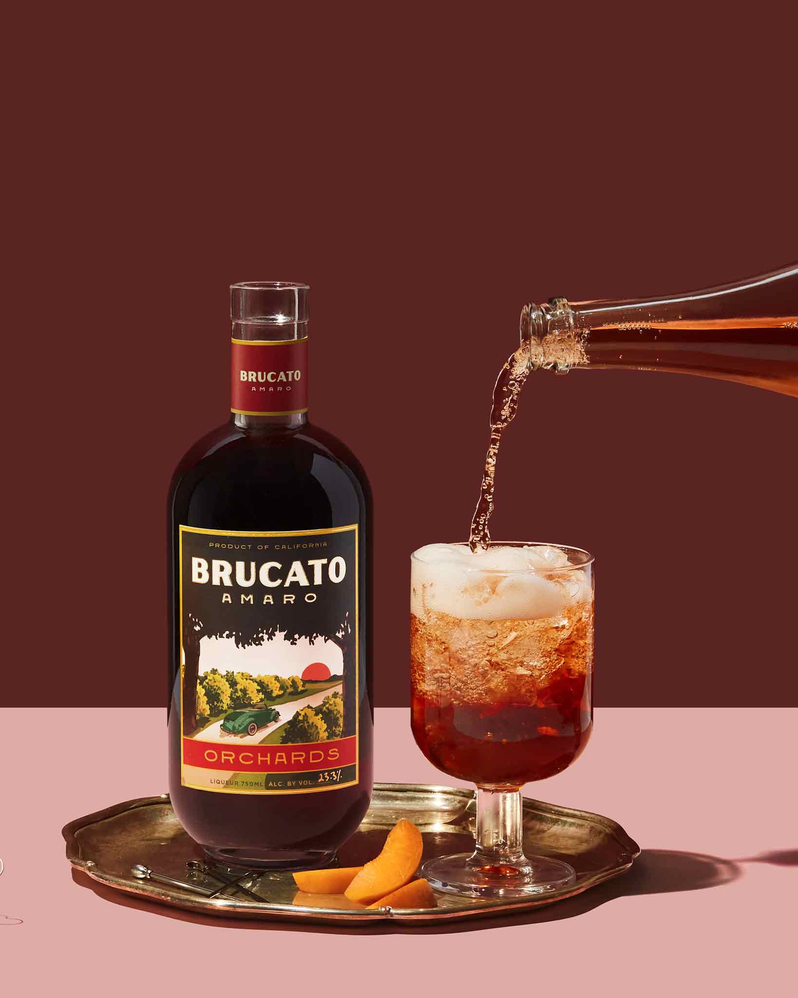 Brucato Amaro Orchards next to bottle pouring a red spritz