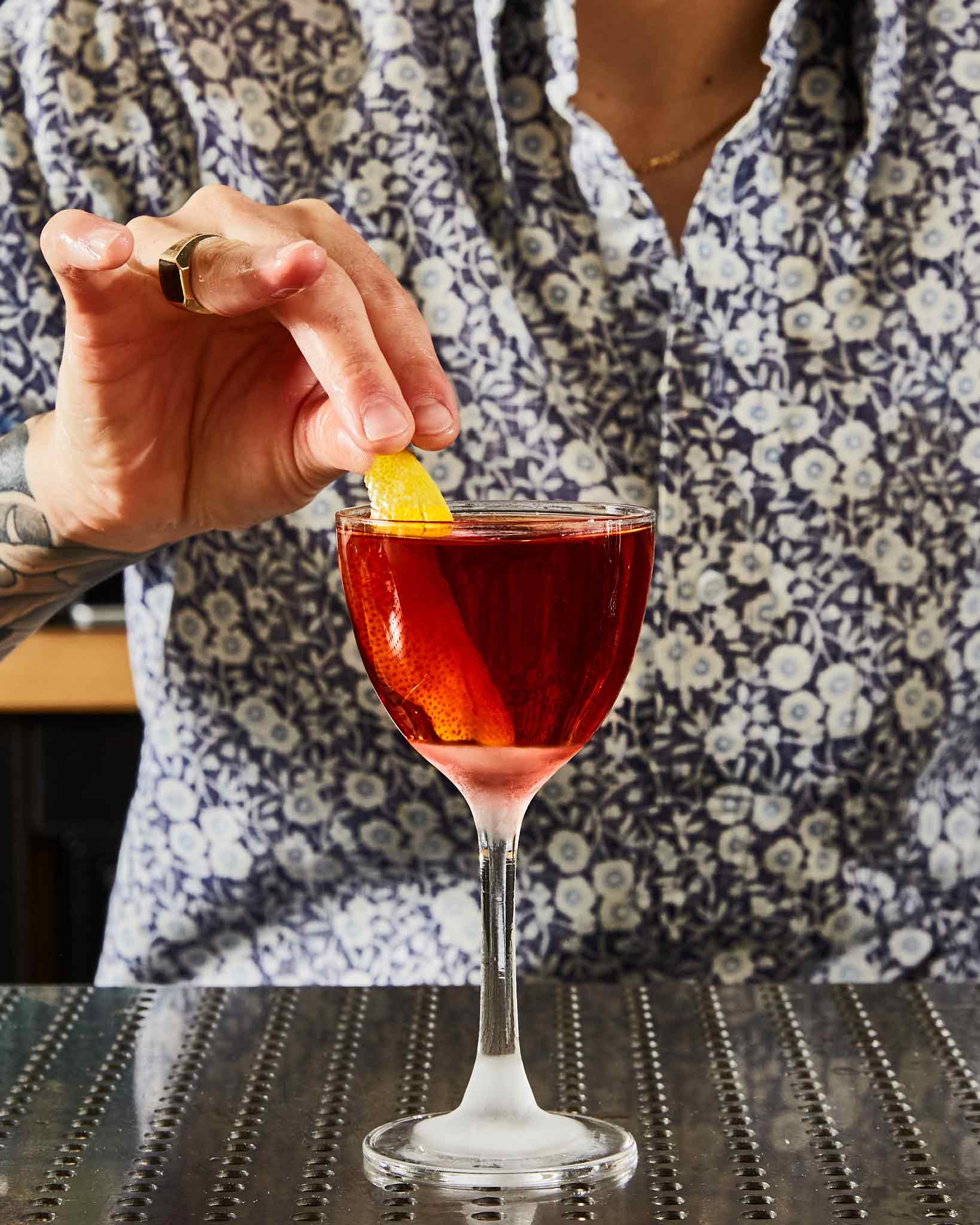 Sycamore Flat cocktail with bartender in pattern shirt placing lemon twist