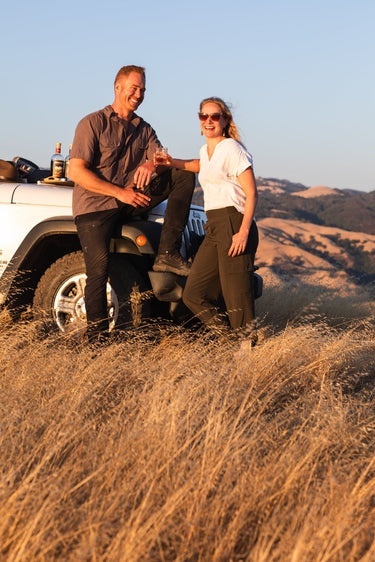 Brucato Amaro founders James and Sierra Clark in front of a jeep smiling.