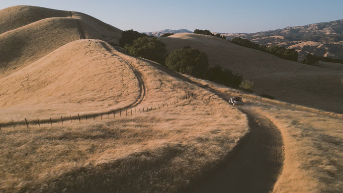 Aerial video of rolling hills, orchards, and coastline in California for Brucato Amaro